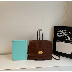 Detailed view of brown retro oil wax leather backpack with golden oval metal hardware