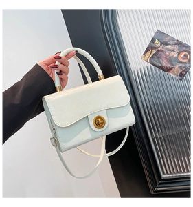 Detail of ivory leather handbag showing the elegant gold twist lock and sturdy handle