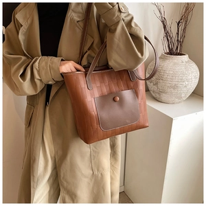 Retro brown oversized tote bag with woven texture worn over a beige trench coat