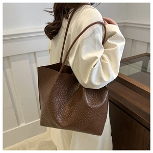 Macro detail of brown woven texture and leather straps on the large tote bag