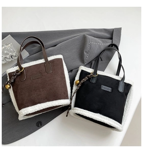 Detail of suede tote bag with white faux shearling trim and fashion leather patch