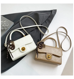 Detail view of stylish crossbody bags with golden twist locks and knot bag charms