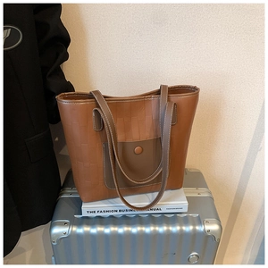 Macro detail of brown woven leather tote bag texture with magnetic pocket on a suitcase