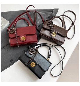 Close-up of vintage leather texture with gold buckle and braided charms on retro bags