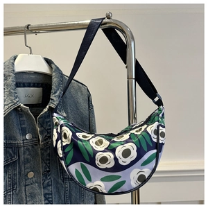 Detail of floral hobo bag with adjustable strap shown against a denim jacket