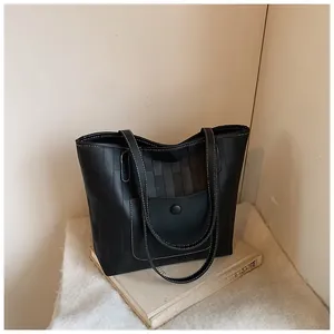Detail of black tote bag with white contrast stitching and rectangular grid texture