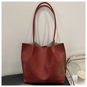 Detail of red oversized tote bag featuring a sophisticated woven texture and long handles