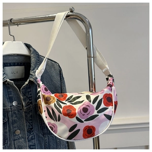 Detail of floral half-moon crossbody bag with adjustable wide strap on metal hanger