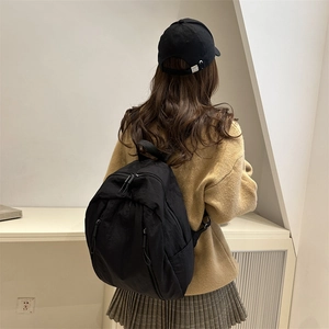 Zaino nero minimalista con tasche a cerniera mostrato sul retro di un modello