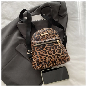 Detail view of mini leopard print backpack with gold hardware and synthetic leather texture