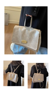 Detail of grey oil wax leather backpack showing top handle and golden metal buckle decoration