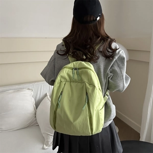 Zaino minimalista in nylon verde chiaro per studenti mostrato su modella in posa
