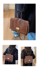 Detail of vintage dark brown oil wax leather backpack with gold metal emblem and straps
