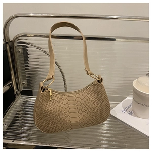 Detailed close-up of beige snakeskin texture and gold zipper on underarm bag