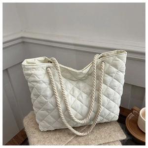 Sac fourre-tout matelassé blanc avec larges anses en corde dans un décor épuré