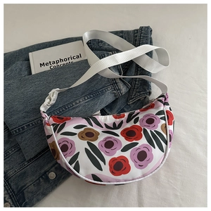 Detail of floral printed crescent bag with adjustable white wide strap and denim styling