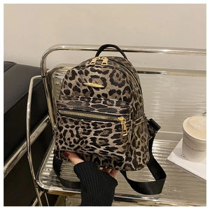 Detail of leopard print mini backpack with golden zippers and casual lifestyle props