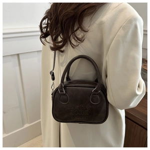 Detail of vintage brown leather handbag with lucky OHIO embossed text and silver hardware