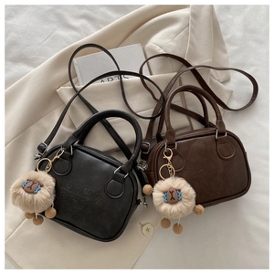 Detail of Boston bags in black and brown featuring lucky OHIO embossing and alpaca charm