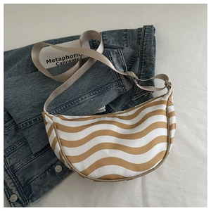 Detail of half-moon bag featuring brown wave patterns and adjustable nylon strap