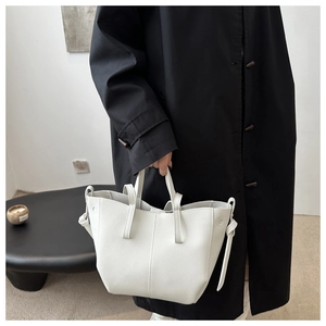 Détail d'un sac cabas blanc en cuir à grain litchi avec nœud latéral élégant