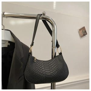 Close-up of black faux snake skin shoulder bag with gold zipper and metal hardware