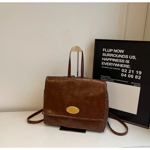 Detail of vintage oil-wax leather backpack with golden metallic buckle and flap closure