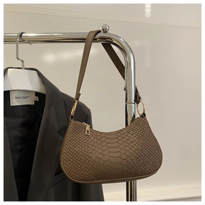 Detailed view of brown crocodile-embossed hobo bag with gold zippers on a hanger