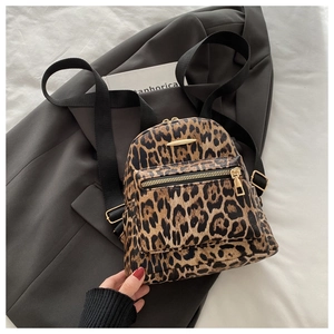 Detail of leopard print mini backpack with golden hardware and textured PU leather
