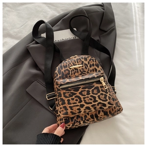 Detail shot of leopard print backpack with gold metal zippers and textured synthetic leather