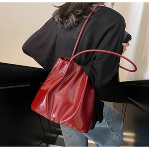 Macro shot of glossy red patent leather surface and fine stitching on the tote bag