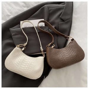 Detail of hobo bag with snakeskin pattern in cream white and dark brown colors