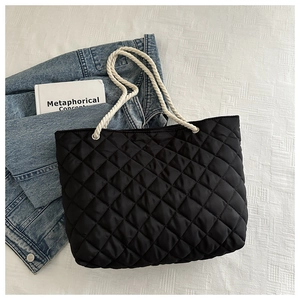 Dettaglio della borsa tote trapuntata nera in nylon con spessi manici in corda bianca