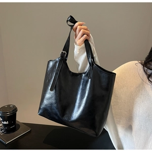 Detailed shot of the black oil-wax leather tote bag with silver buckle and smooth finish