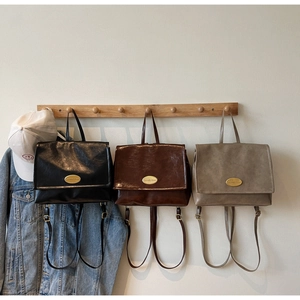 Detailed trio of vintage oil wax leather backpacks in black, brown, and grey with gold logo