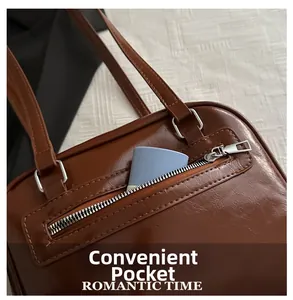 Close-up of portable front pocket on brown PU leather square bag showing storage detail