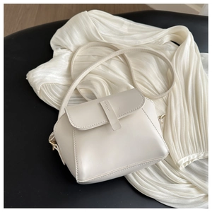 Détail du sac à bandoulière en cuir blanc crème avec fermoir doré et rabat chic