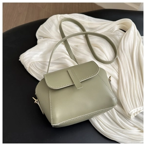 Détail du sac coquillage vert sauge montrant le cuir mat et la boucle en métal doré