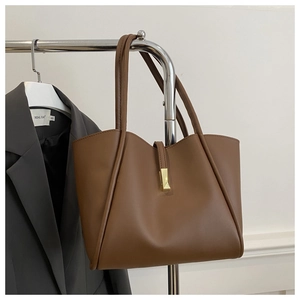 Detailaufnahme einer braunen Leder-Tote-Bag mit einem goldenen rechteckigen Metallverschluss