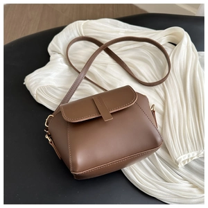 Détail du sac à bandoulière marron caramel en similicuir avec rabat et ferrures dorées