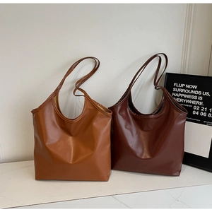 Detail of light brown and dark coffee tote bags in high-quality textured synthetic leather