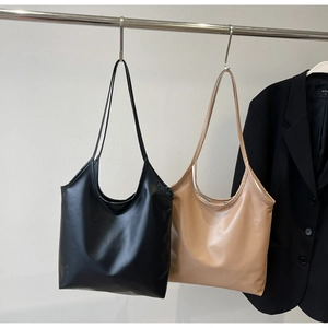 Minimalist leather tote bags in black and beige hanging for professional commuting style