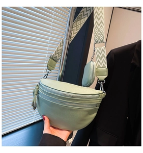 Detail view of mint green crossbody chest bag with adjustable wide geometric strap