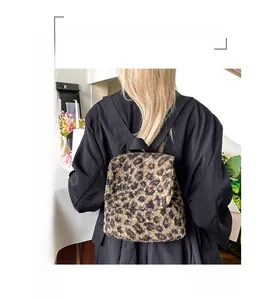 Détail du sac à dos en peluche léopard montrant la texture douce et les bretelles