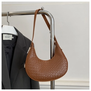 Détail d'un sac hobo marron à texture tissée avec des garnitures métalliques argentées