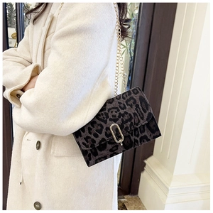 Détail du sac léopard avec bandoulière en chaîne dorée et boucle en métal en forme de U