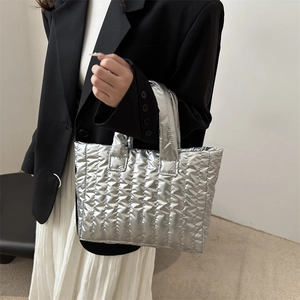 Metallic silver quilted tote bag with vertical stitching for a stylish look