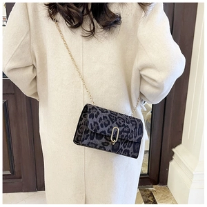 Détail du sac bandoulière léopard gris foncé avec chaîne dorée et texture en velours