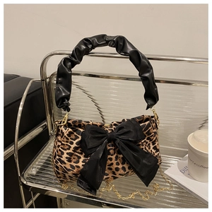 Detailed leopard print shoulder bag with black bow and gold chain on display