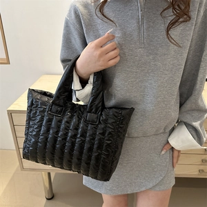 Fashionable black quilted nylon tote bag with vertical stripes and padded handles
